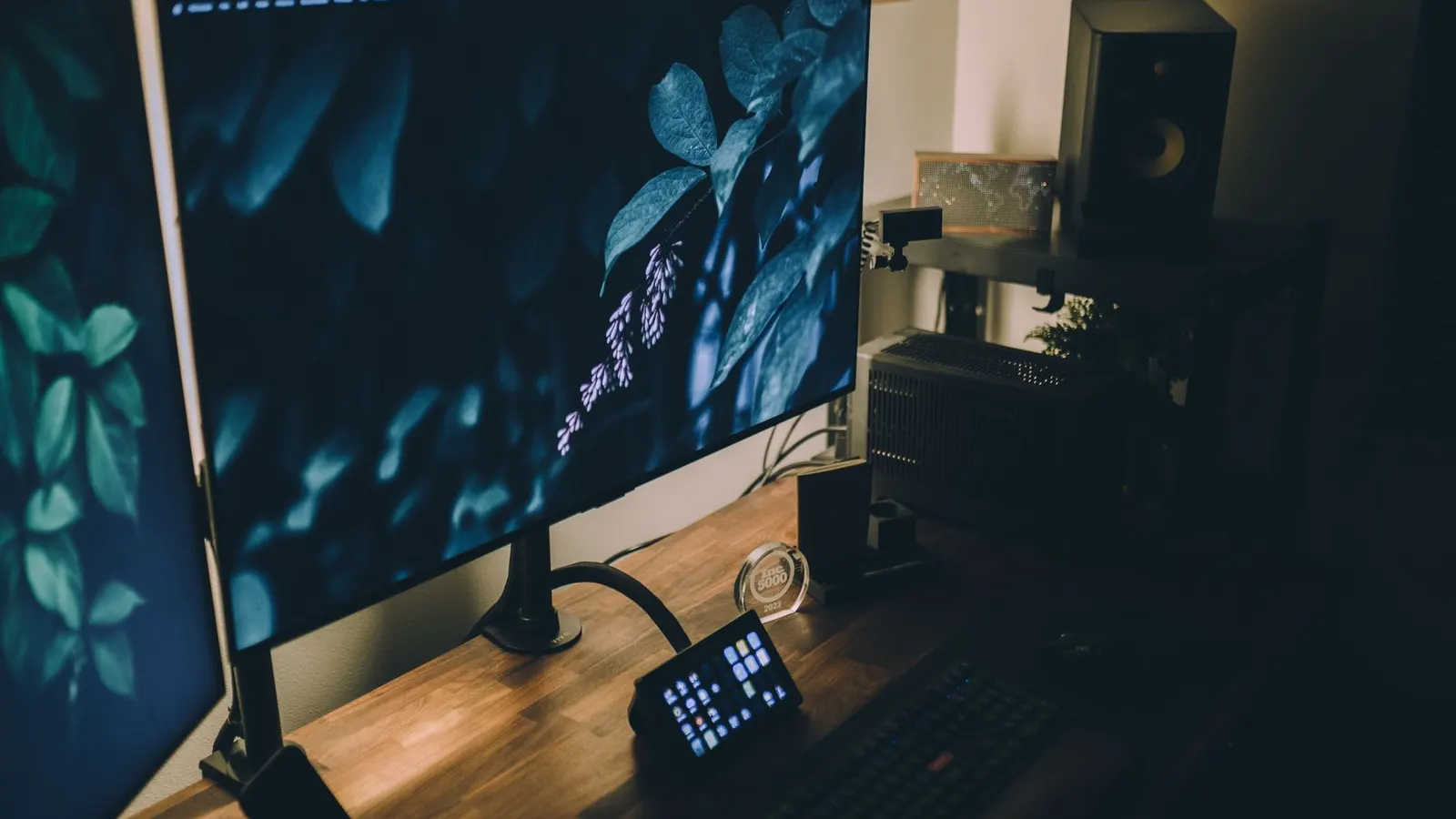 A stylish workspace setup featuring dual monitors, ambient lighting, and a wooden desk.